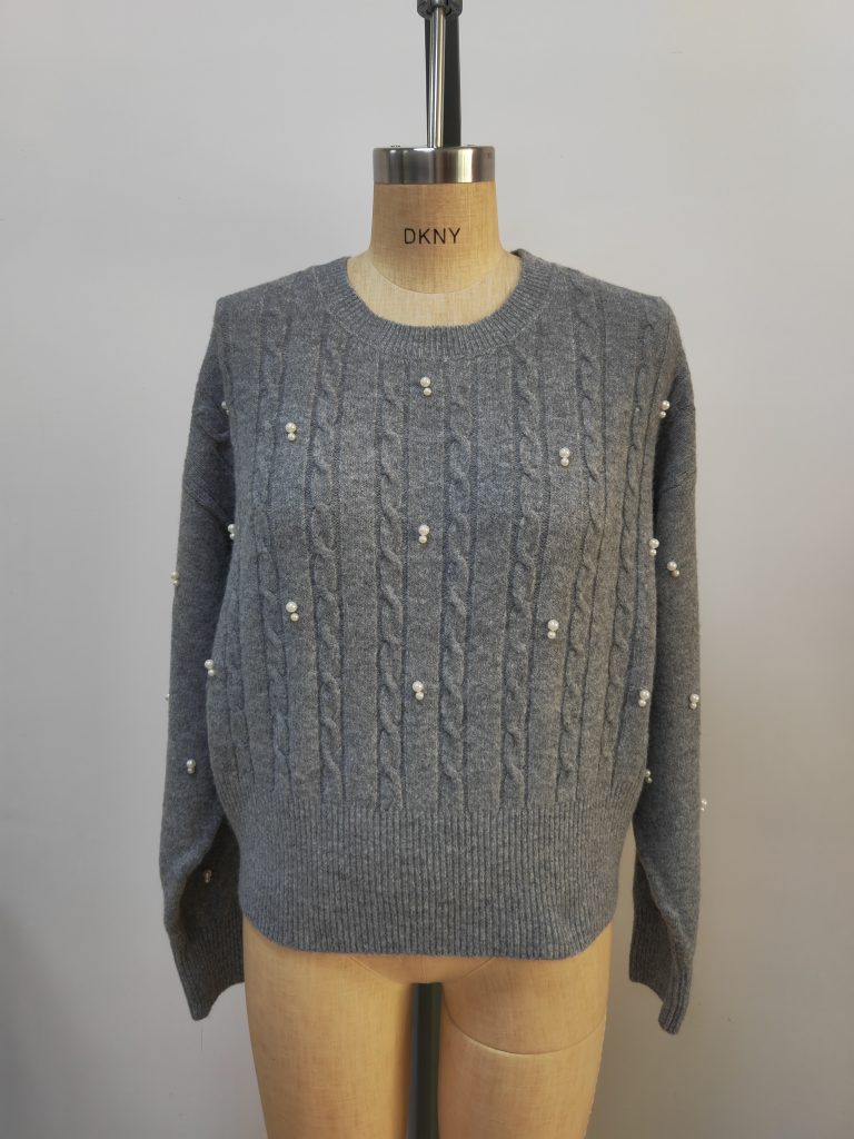 Grey cable knit sweater with pearl details on mannequin
